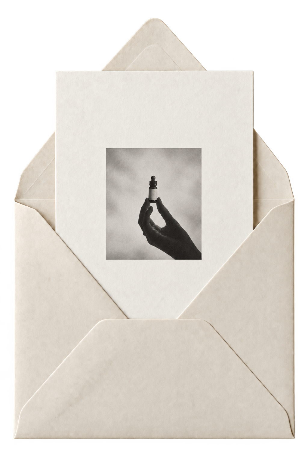 An open ivory envelope holding a small monochrome photograph of a hand with a Prophet essence